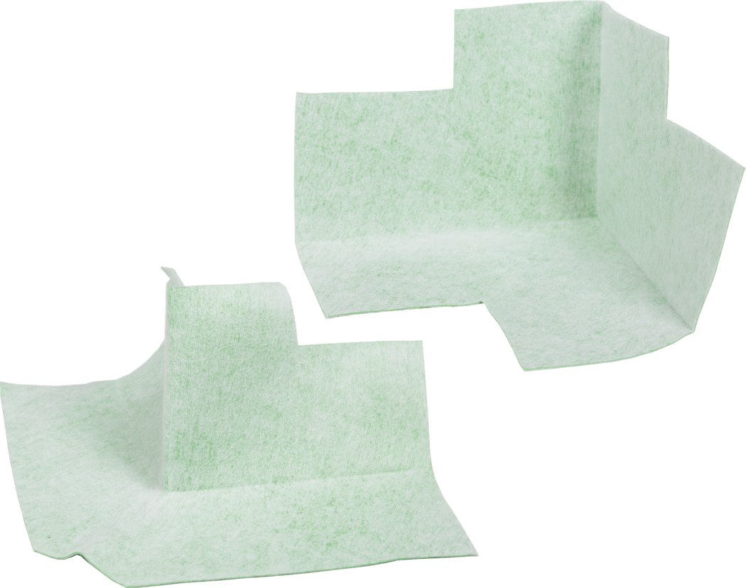 codex_Dummy_Dichteck_composing_2019-01 Zwei hellmintgrüne, wegwerfbare absorbierende Eckauflagen vor weißem Hintergrund. Die nichtgewebten, strukturierten Pads sind vorgeformt mit einer erhöhten vertikalen Ecke und flachen umlaufenden Laschen, was auf den Einsatz als geformte Unterlagen oder Schutzliner für Möbel, medizinische oder hygienische Anwendungen hinweist. Das Material wirkt weich, faserig und leicht durchscheinend mit einer gesprenkelten Struktur; die Kanten sind unregelmäßig geschnitten. Die Auflagen sind getrennt und in unterschiedlichen Winkeln dargestellt, wodurch die dreidimensionale gefaltete Form und die flachen Basisflächen zur Aufnahme von Flüssigkeiten oder zum Schutz von Oberflächen betont werden.